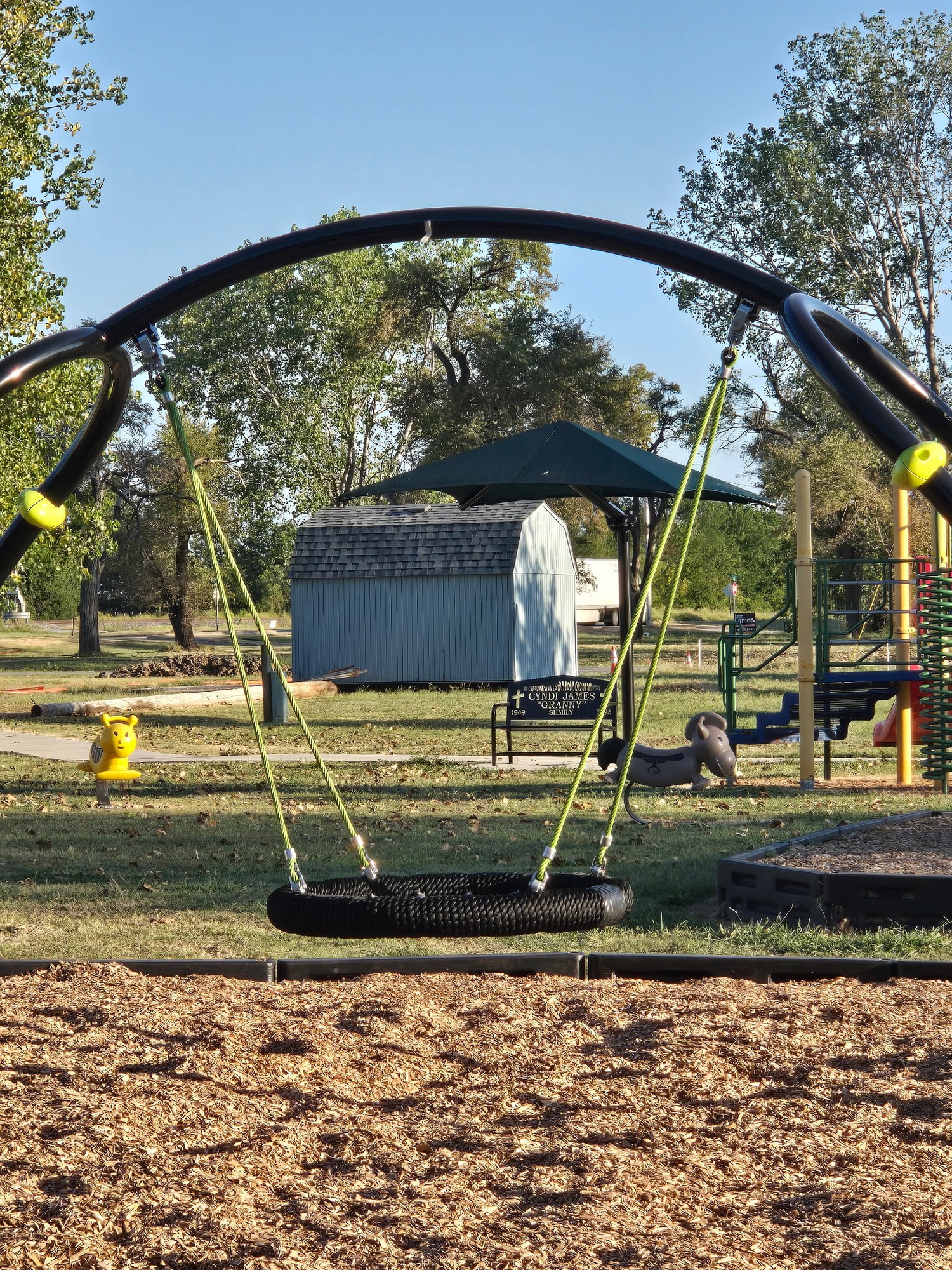 Nest swing with park and memorial bench beyond