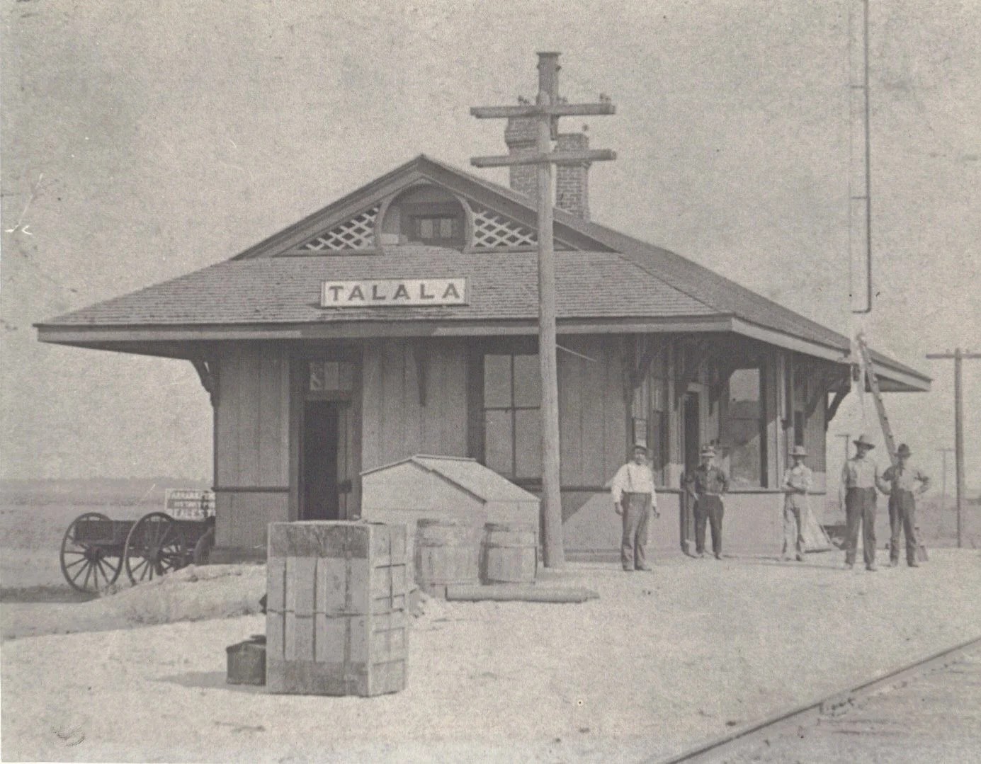 Historic photograph of the Talala railroad depot with the town name on the building